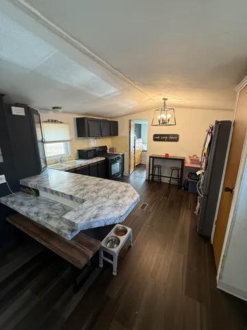 a room with kitchen island a wooden floor and a sink
