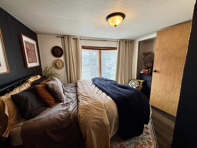 a bed sitting in a bedroom next to a window