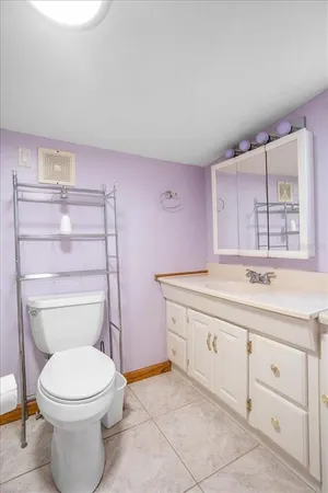 a bathroom with a granite countertop toilet sink and mirror