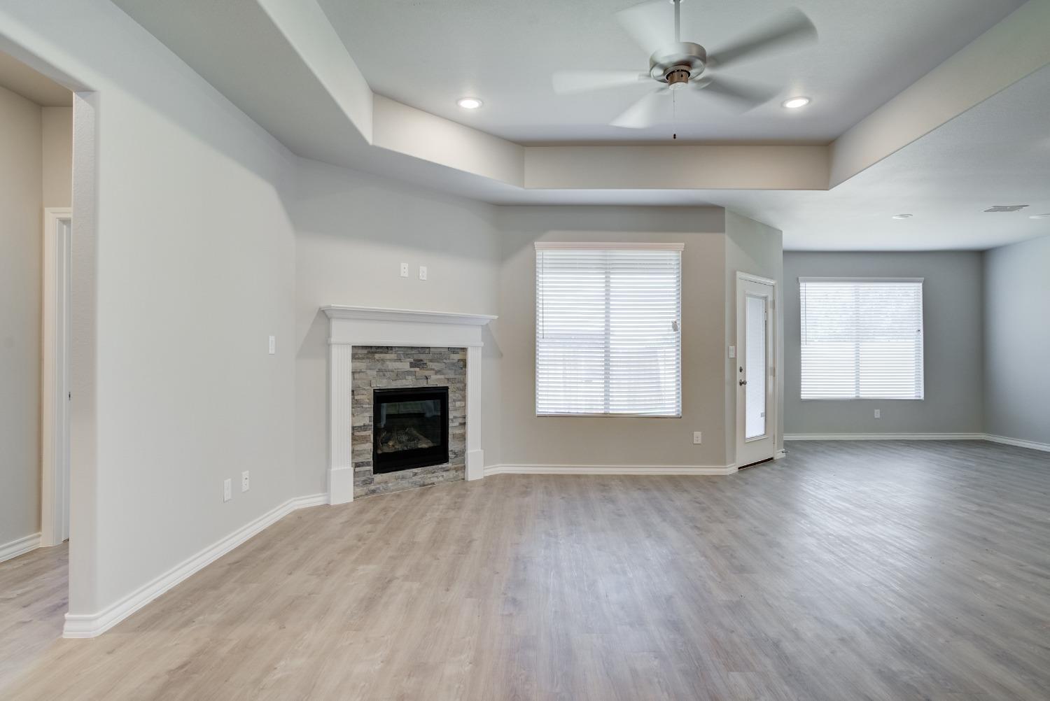 7602 60th Street Lubbock, TX 79407 - Photo 15 of 33 an empty room with windows and a fireplace