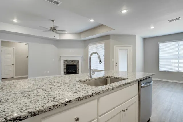 a bathroom with a granite countertop sink and a mirror