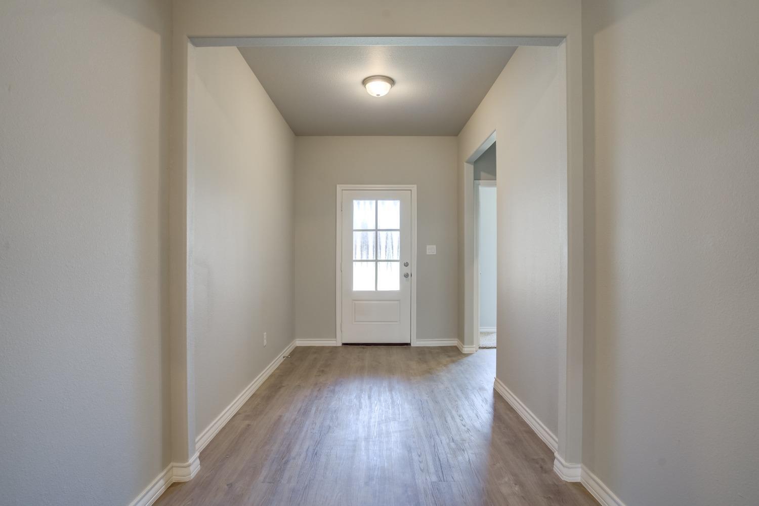 7602 60th Street Lubbock, TX 79407 - Photo 21 of 33 an empty room with wooden floor and windows