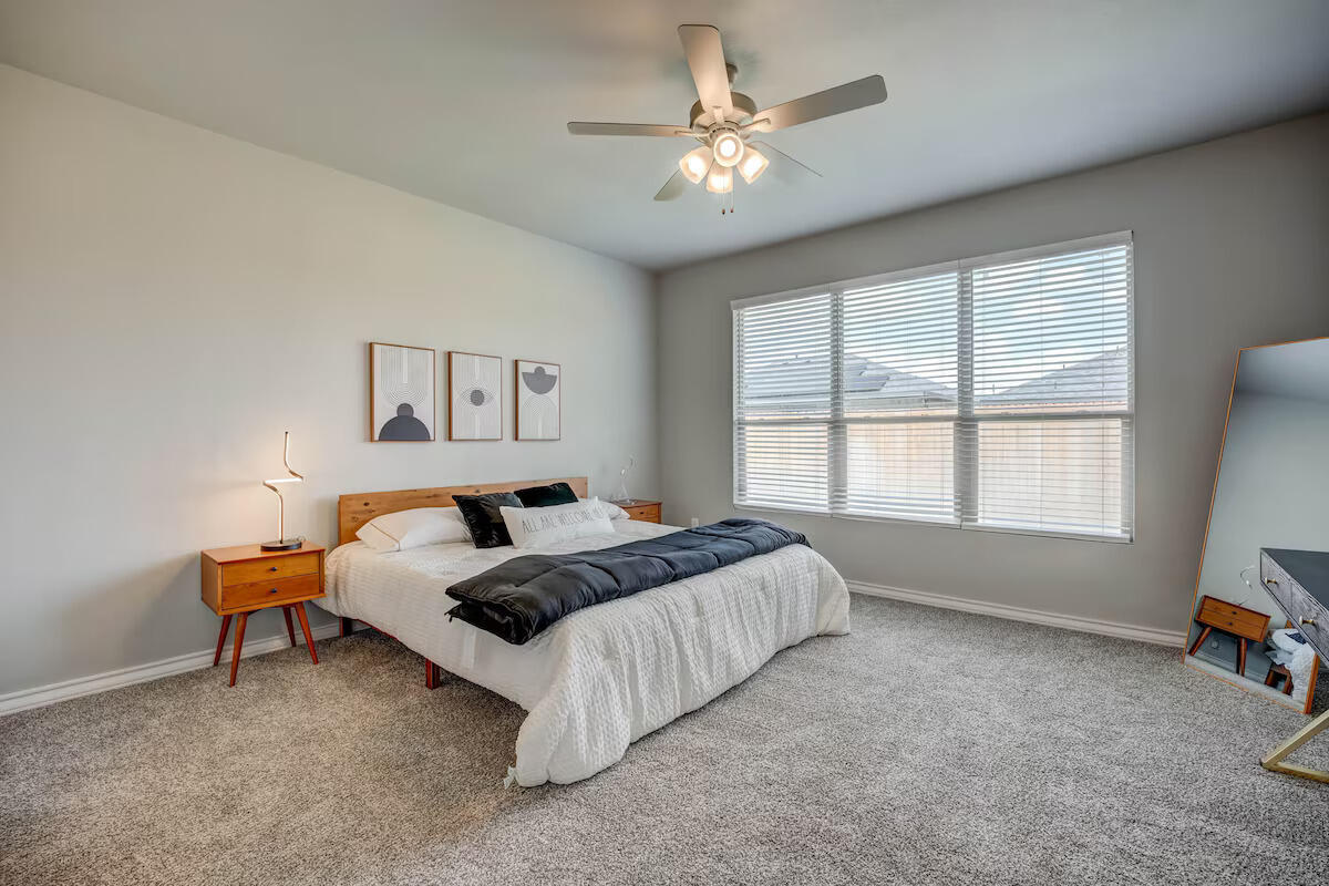 7602 60th Street Lubbock, TX 79407 - Photo 24 of 33 a bed room with a bed and a couch