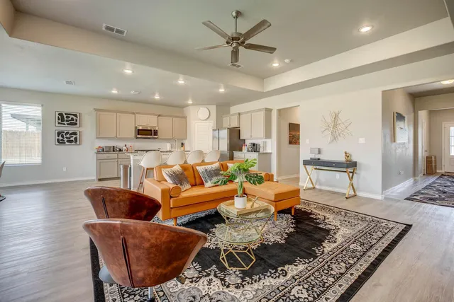 a kitchen with stainless steel appliances kitchen island granite countertop a stove top oven a sink a dining table and chairs