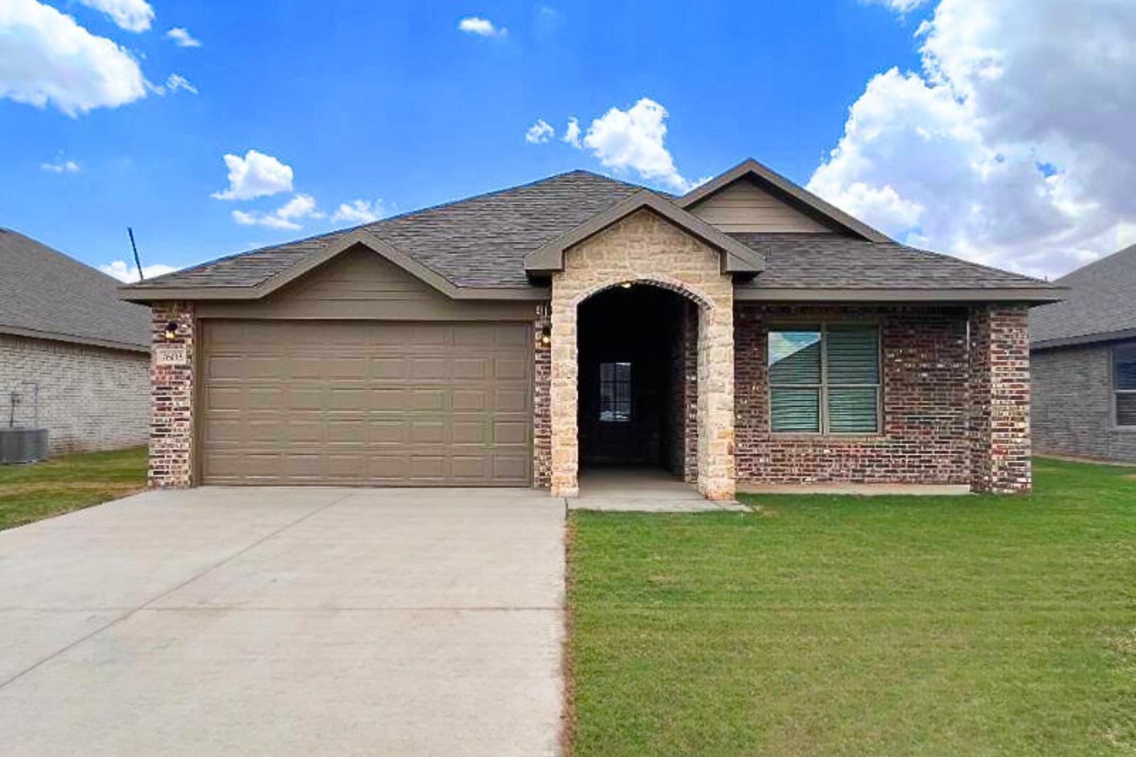 7602 60th Street Lubbock, TX 79407 - Photo 6 of 33 a front view of a house with a yard and garage