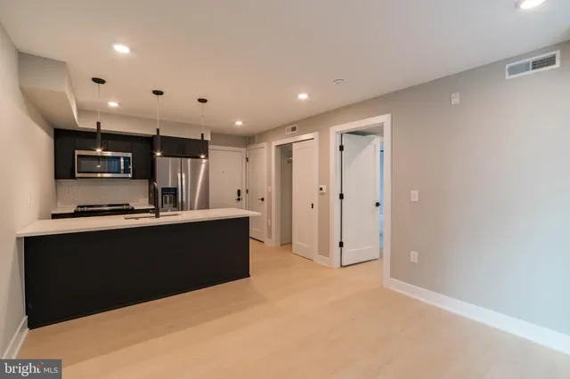 a view of kitchen with stainless steel appliances cabinets