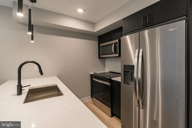 a kitchen with a refrigerator sink and stainless steel appliances
