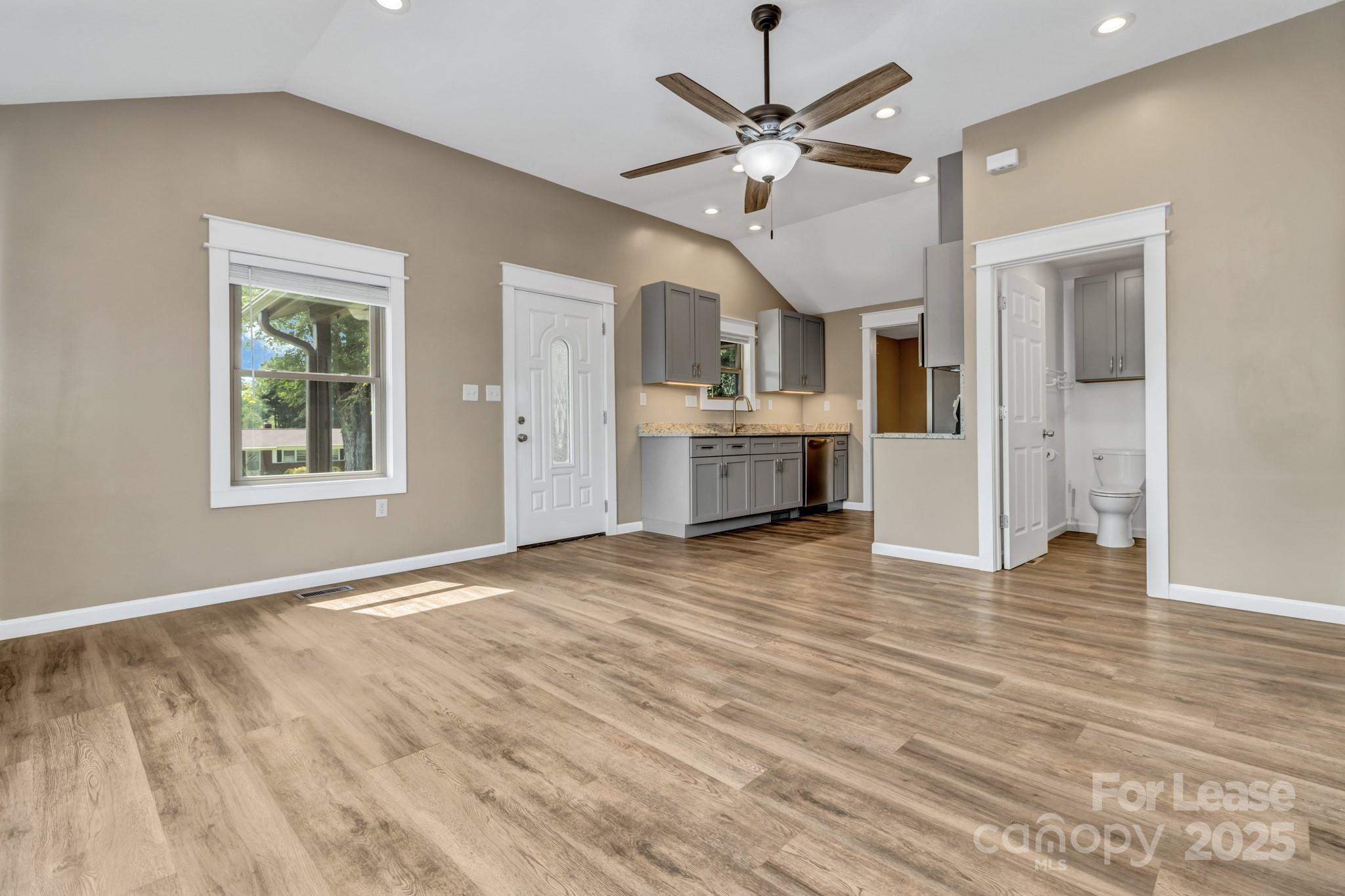 150 Oak Hill Road Candler, NC 28715 - Photo 12 of 44 a view of a kitchen with wooden floor and a ceiling fan