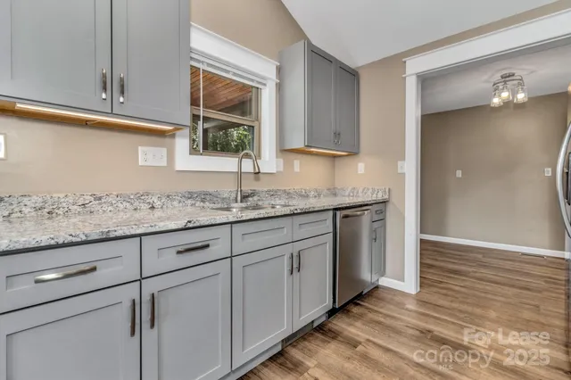 a kitchen with granite countertop cabinets and window