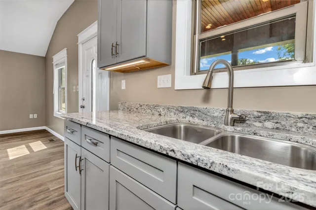 a kitchen with granite countertop a sink and a wooden cabinets