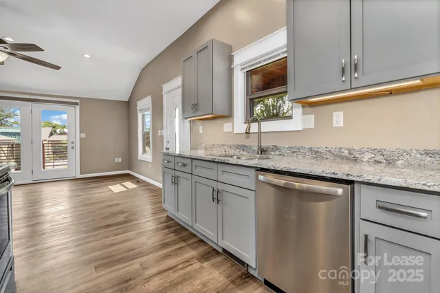 a kitchen with stainless steel appliances granite countertop a sink stove and cabinets