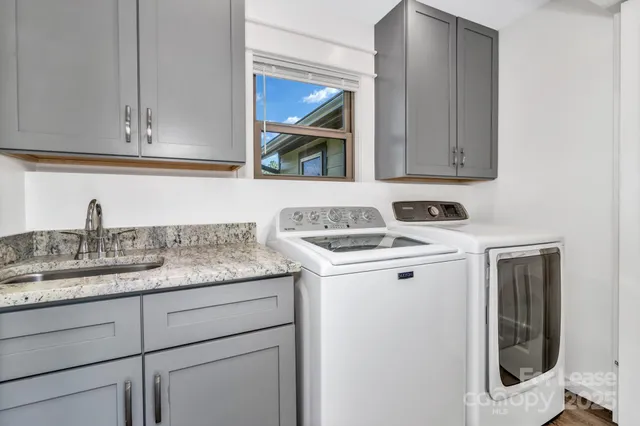 a utility room with sink dryer and washer