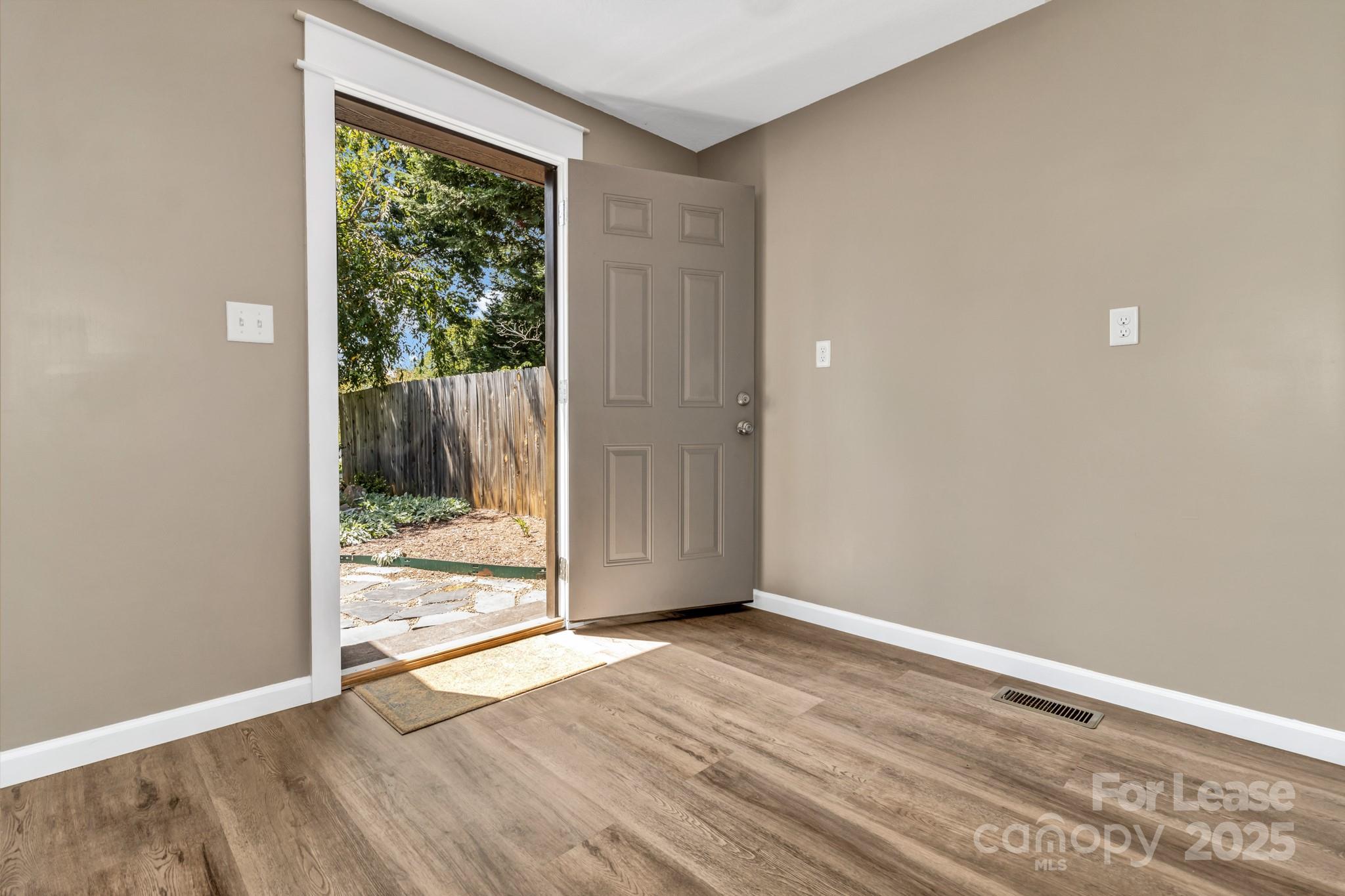 150 Oak Hill Road Candler, NC 28715 - Photo 24 of 44 an empty room with wooden floor and windows