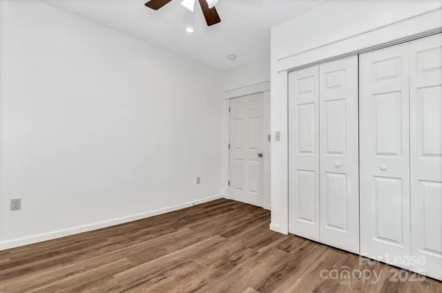 a view of an empty room with wooden floor