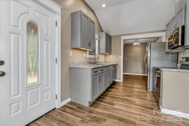 a kitchen with stainless steel appliances granite countertop a refrigerator a stove and a sink with large countertops