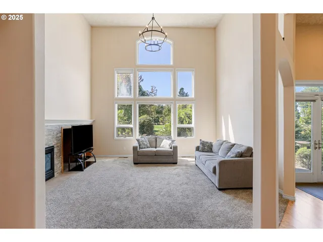 a living room with furniture large window and a fireplace