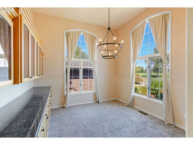 a bedroom with a bed lamp and a large window