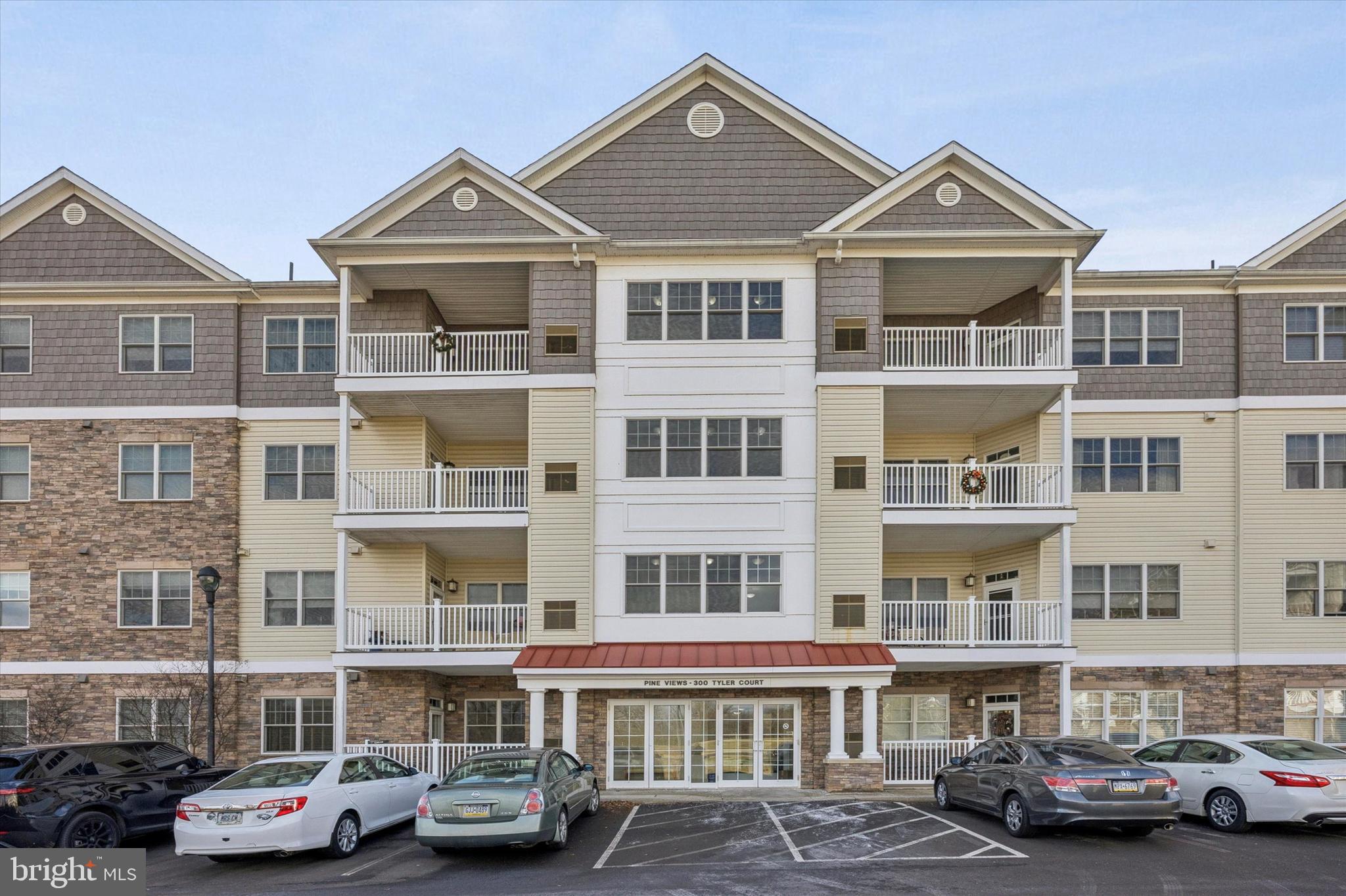 a front view of a building with parked cars