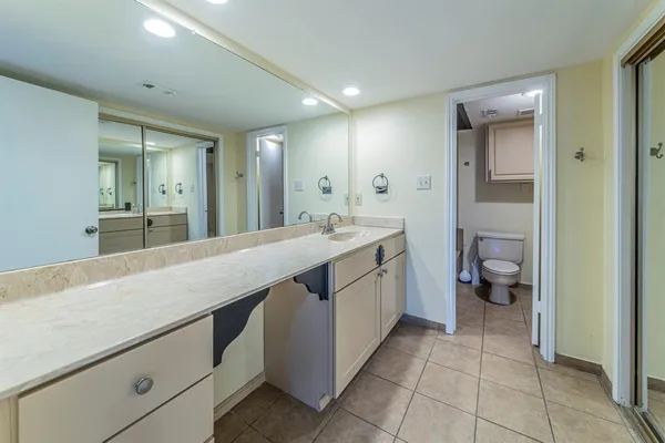 a spacious bathroom with a granite countertop sink mirror and toilet