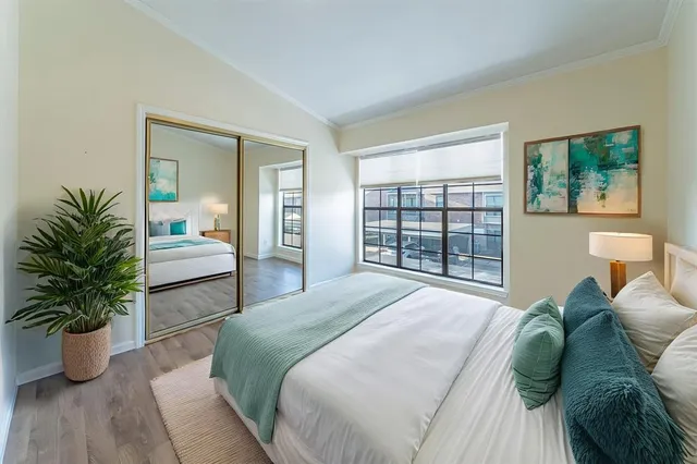 a bedroom with a bed and a potted plant