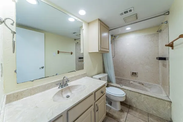 a bathroom with a granite countertop sink toilet a large mirror and shower