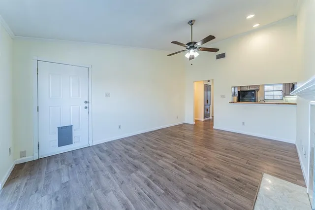 a view of empty room with wooden floor