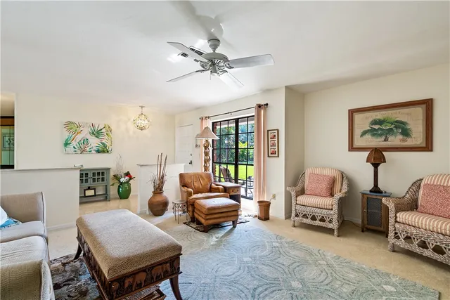 a living room with furniture a ceiling fan and a rug