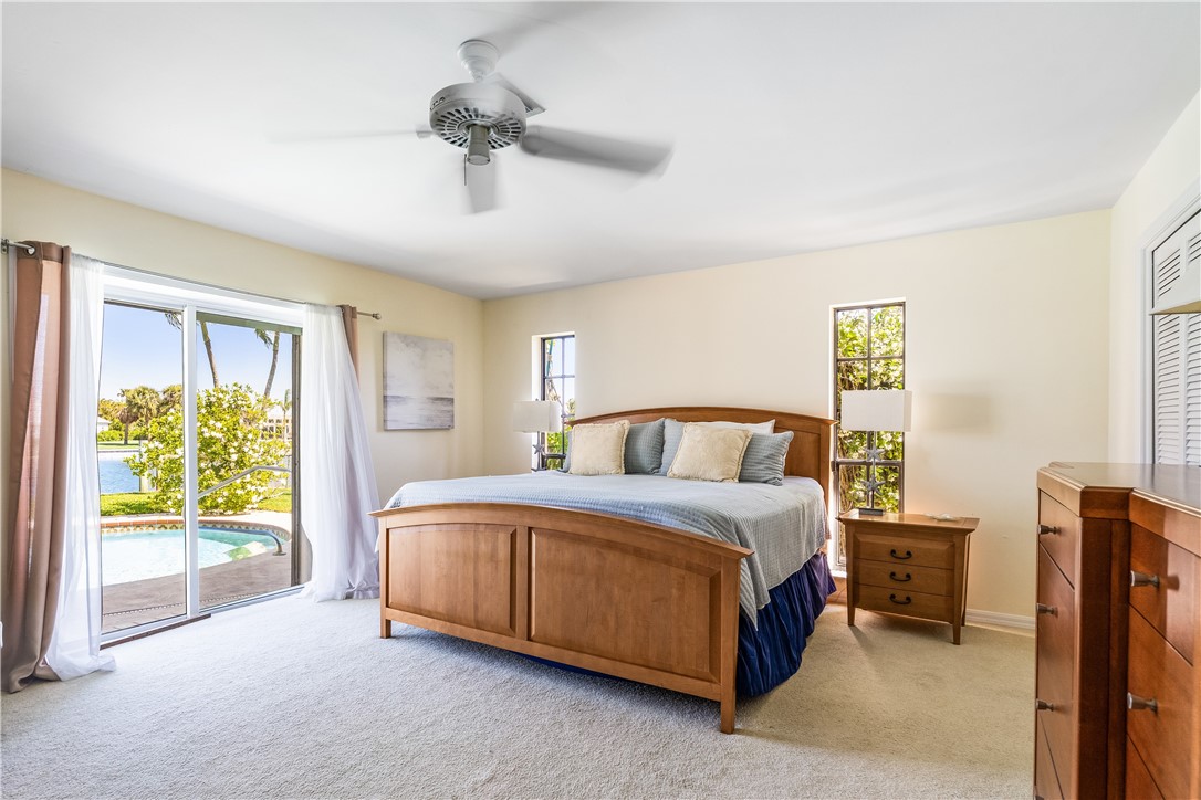 635 Live Oak Road Vero Beach, FL 32963 - Photo 16 of 35 a large bedroom with a bed lamp and a large window