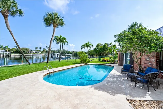 a view of a house with swimming pool and sitting area