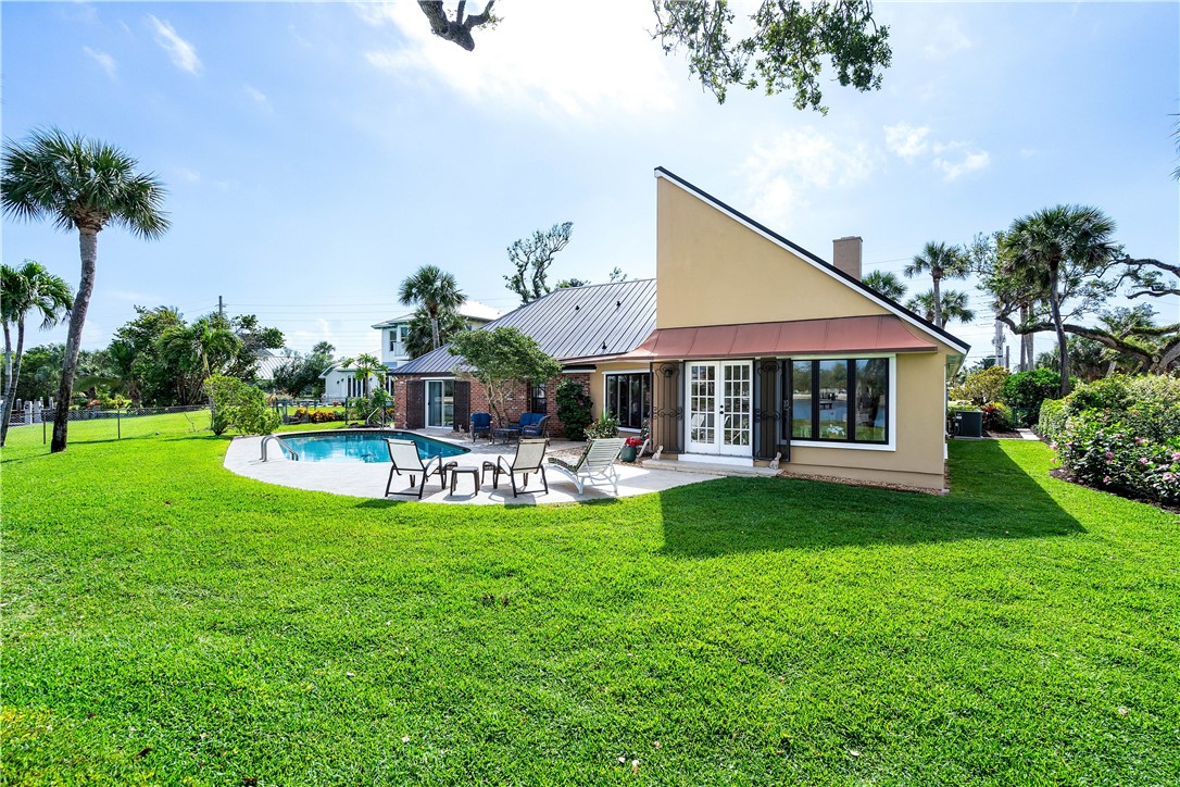 635 Live Oak Road Vero Beach, FL 32963 - Photo 29 of 35 a front view of a house with swimming pool having outdoor seating