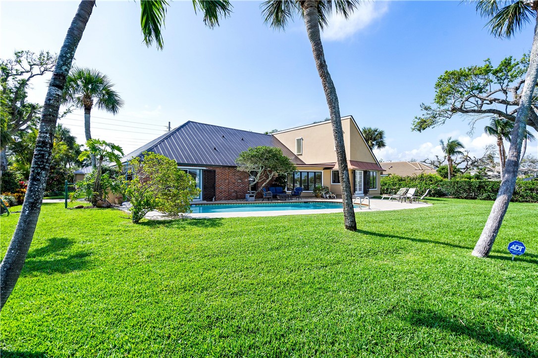 635 Live Oak Road Vero Beach, FL 32963 - Photo 32 of 35 a view of a house with a yard and palm trees
