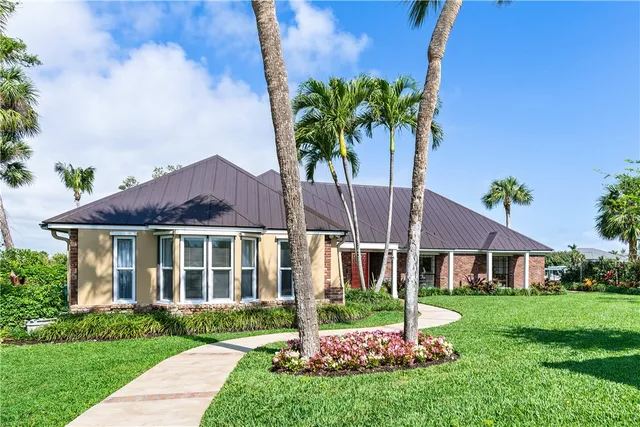 a front view of a house with a garden and yard