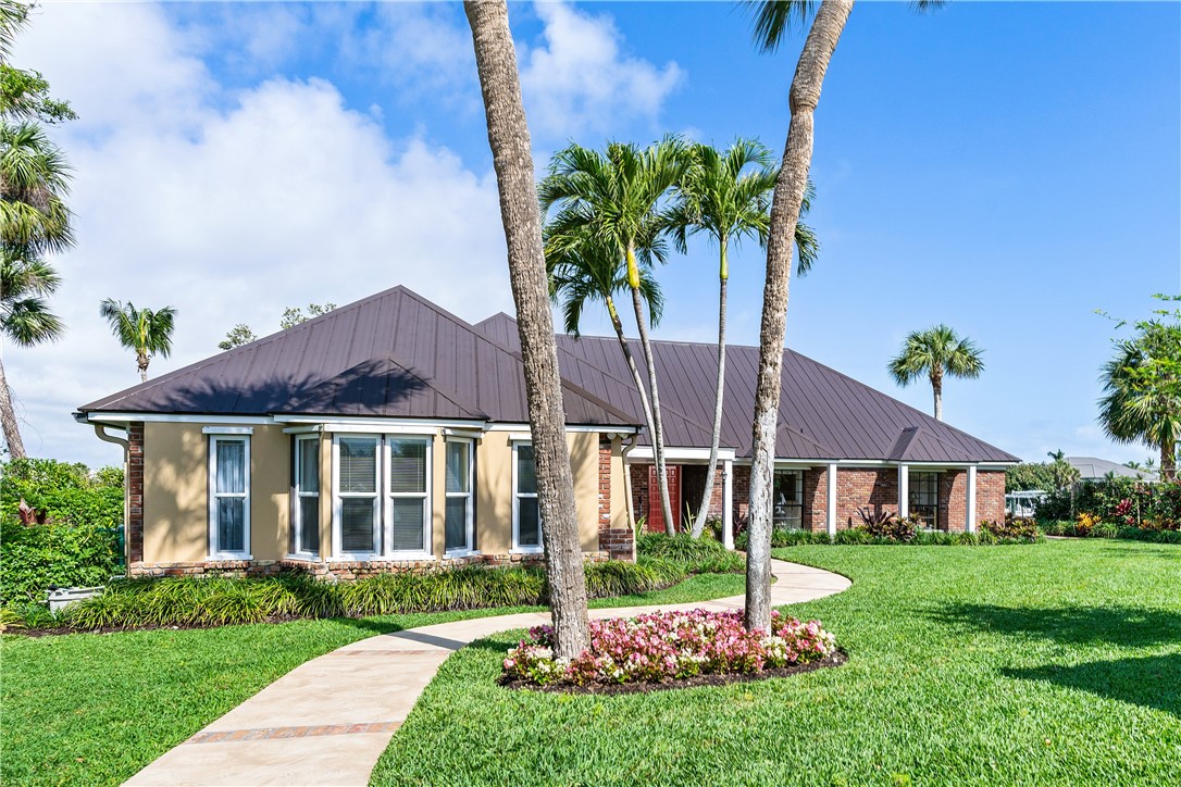 635 Live Oak Road Vero Beach, FL 32963 - Photo 4 of 35 a front view of a house with a garden and yard