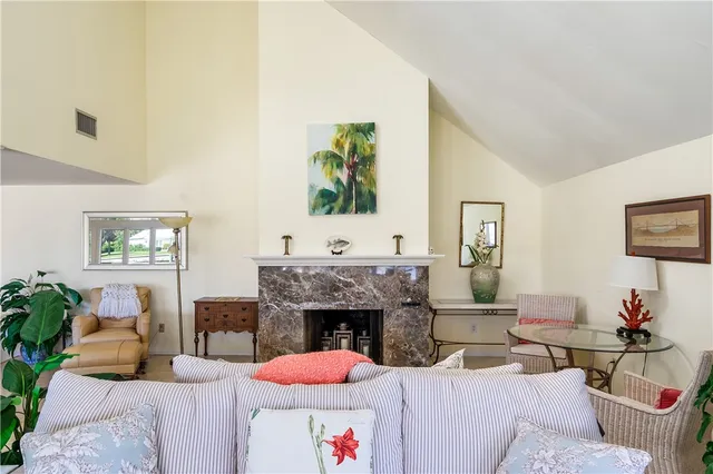 a living room with furniture a fireplace and a potted plant