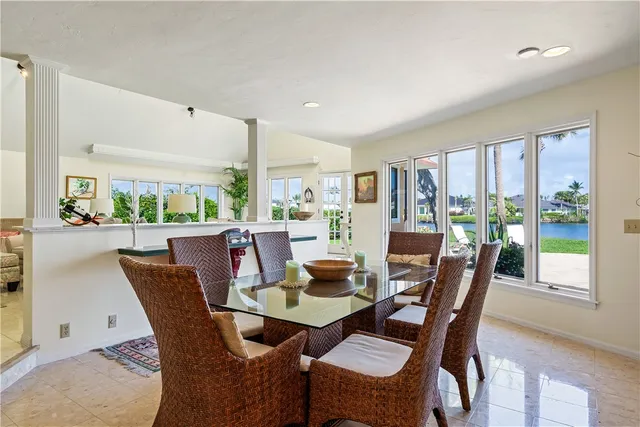 a dining room with furniture a rug and a floor to ceiling window