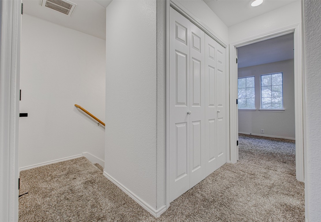 6249 Negley, Unit B Kyle, TX 78640 - Photo 17 of 26 Hall with light carpet, a textured wall, and an upstairs landing