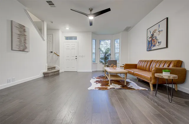 a living room with furniture and a wooden floor