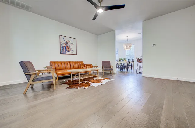 a living room with furniture and a wooden floor