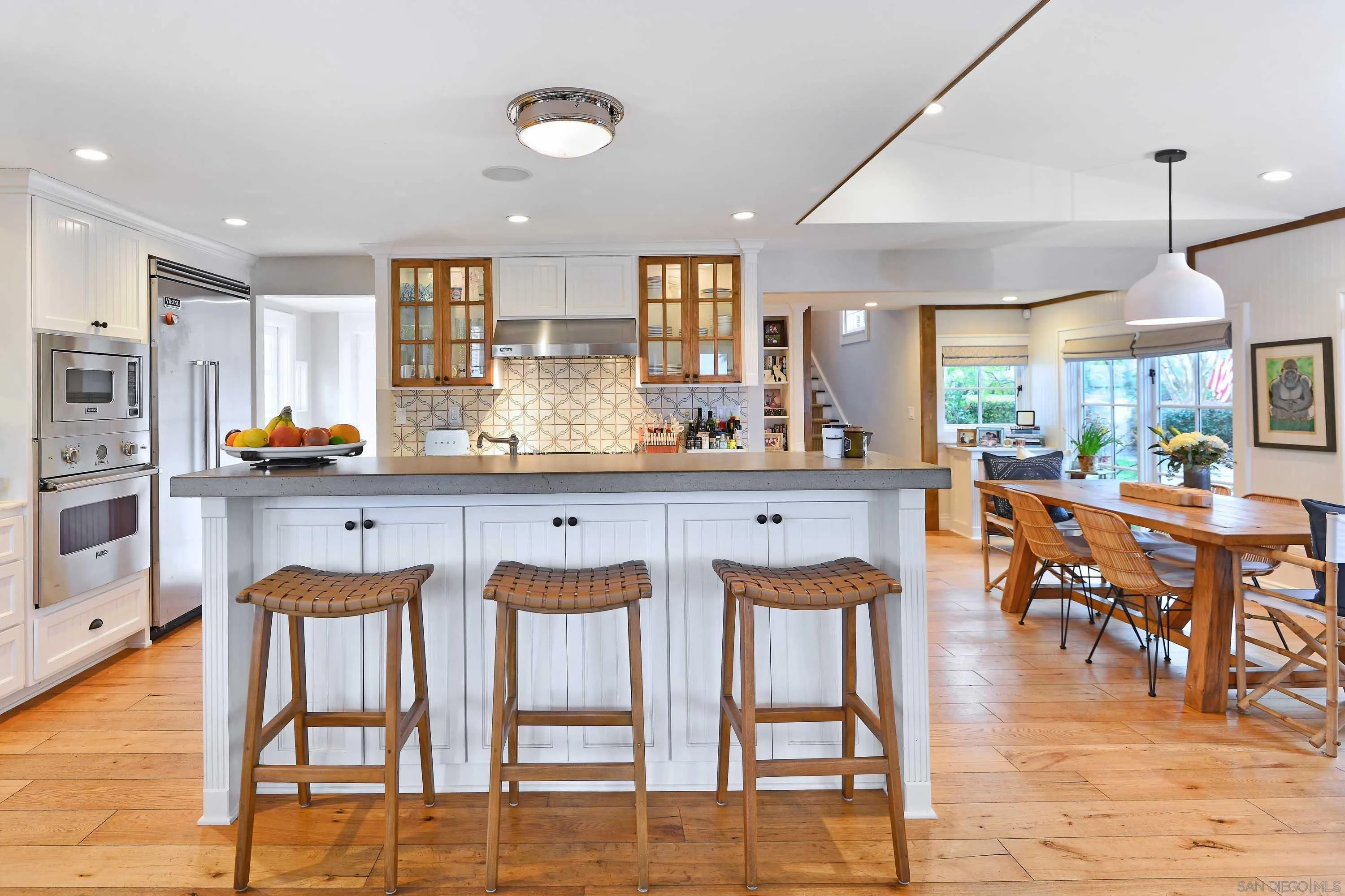 5844 Beaumont Avenue La Jolla, CA 92037 - Photo 8 of 26 a dining hall with stainless steel appliances kitchen island granite countertop a dining table chairs and view of living room