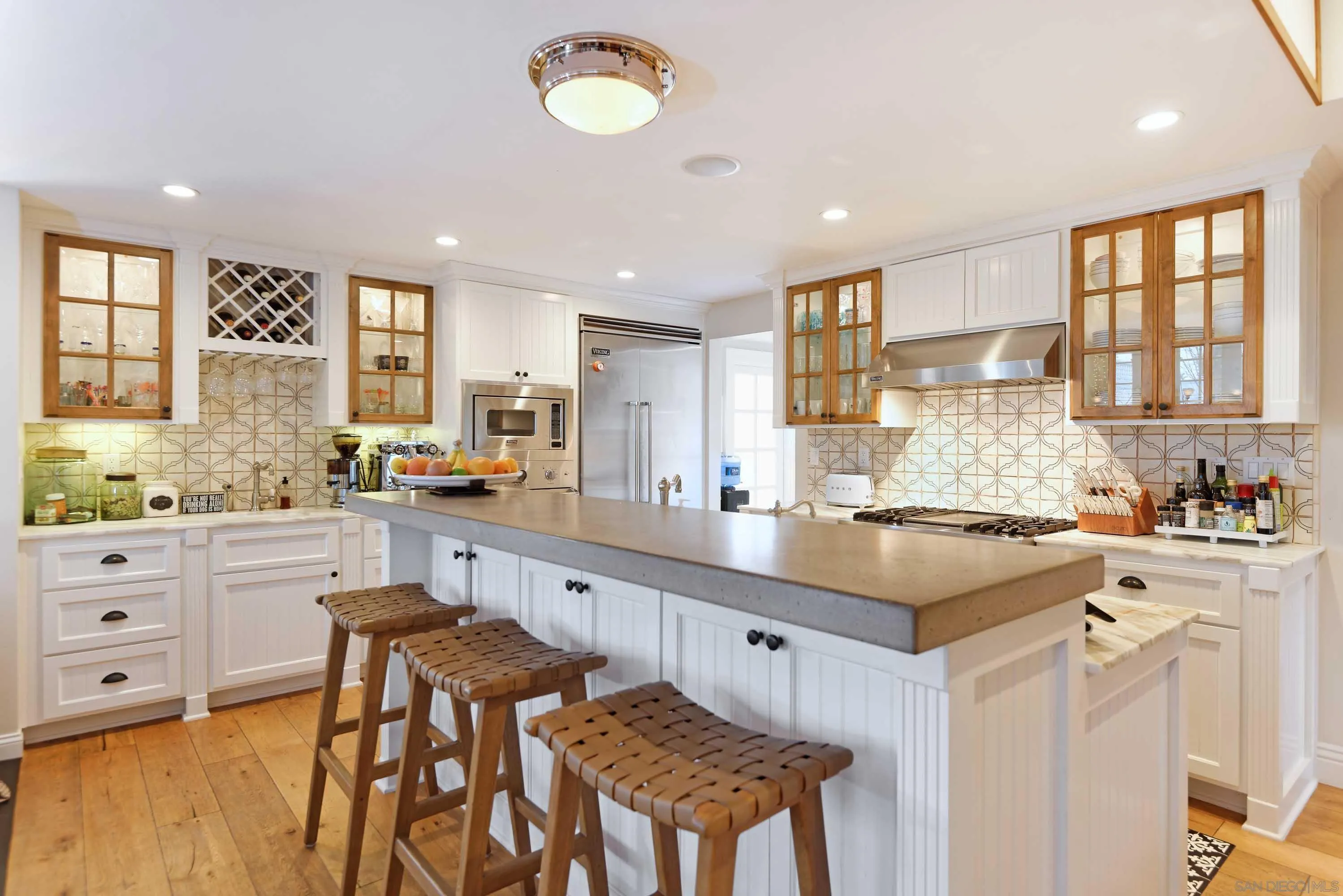 5844 Beaumont Avenue La Jolla, CA 92037 - Photo 9 of 26 a kitchen with stainless steel appliances granite countertop a stove a sink dishwasher and a refrigerator with wooden cabinets