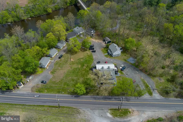 a view of a white house with a big yard and large trees