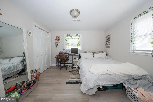 a view of a white house with large windows and a small yard