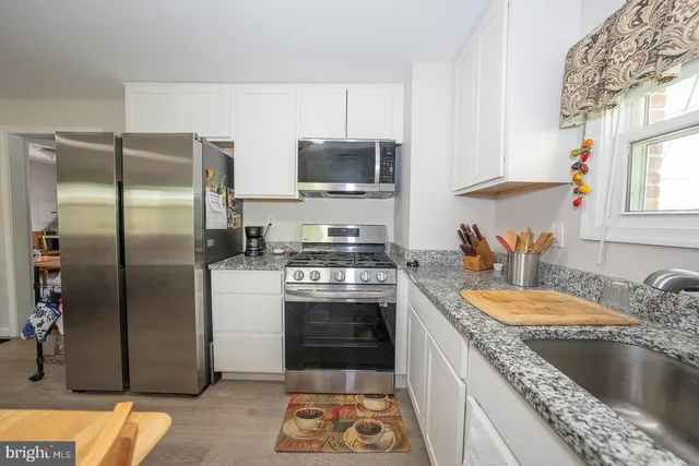 a front view of a house with a garden and trees