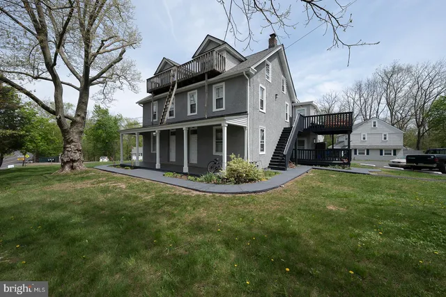 a view of a house with a patio table and chairs under an umbrella
