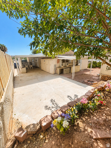 131 Rickie Road Washington, UT 84780 - Photo 6 of 31 Expansive concrete patio area featuring a covered outdoor space with built-in cabinetry for storage and workbench.