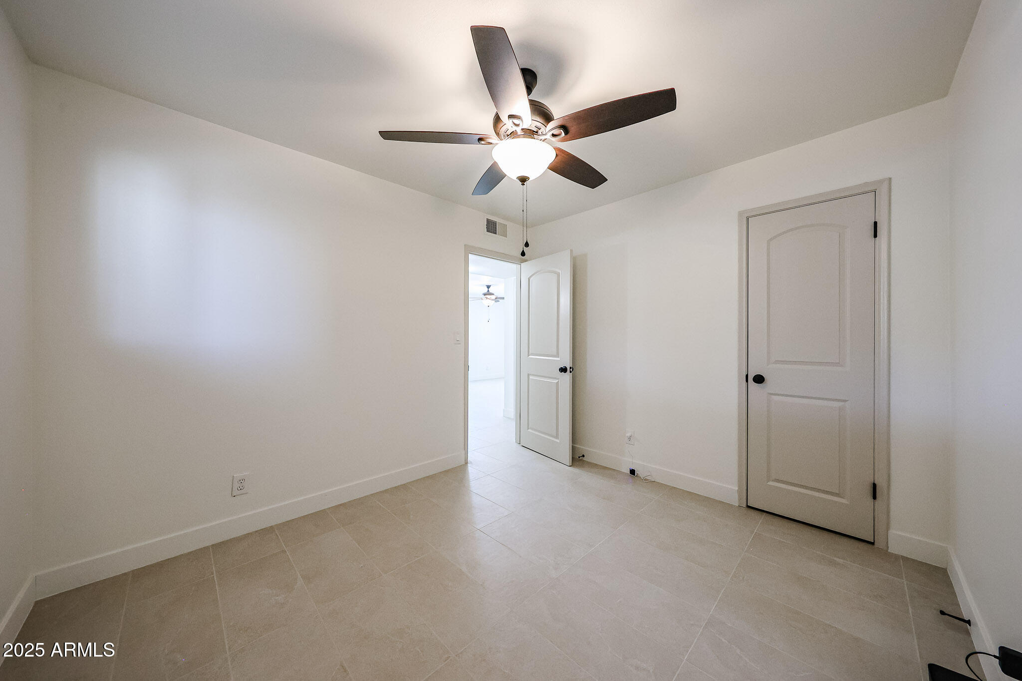 10202 North 15th Avenue, Unit 2 Phoenix, AZ 85021 - Photo 15 of 34 an empty room with closet and a chandelier fan