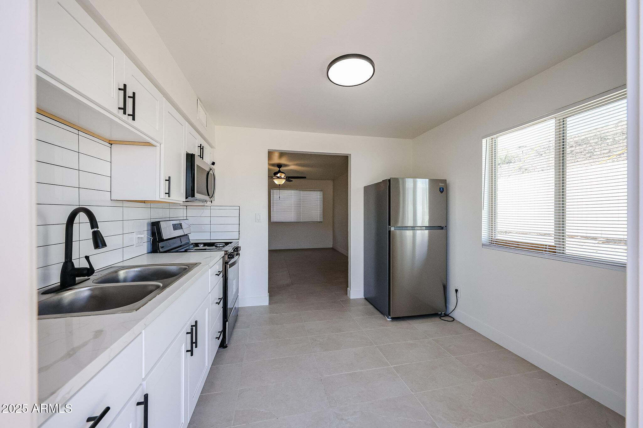 10202 North 15th Avenue, Unit 2 Phoenix, AZ 85021 - Photo 17 of 34 a kitchen with stainless steel appliances granite countertop a sink and a refrigerator