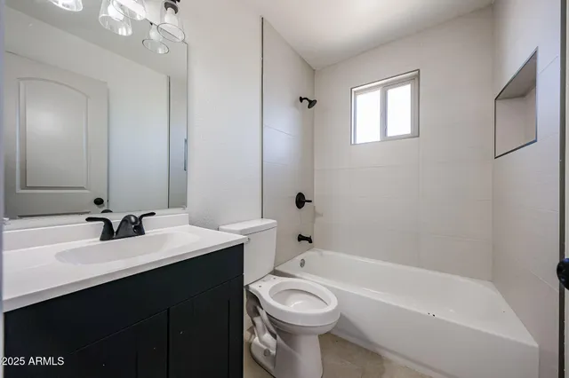 an empty room with ceiling fan and window