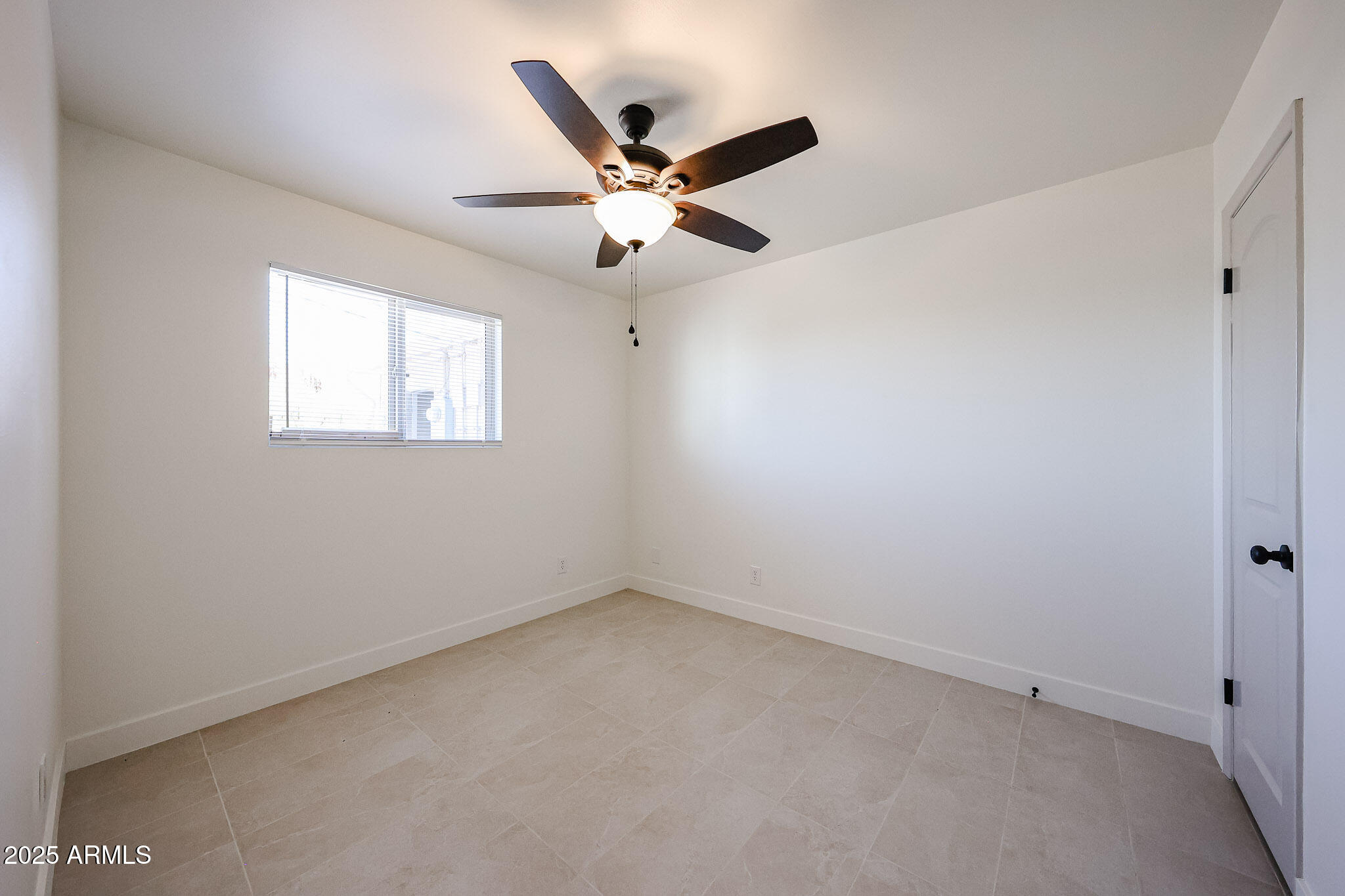 10202 North 15th Avenue, Unit 2 Phoenix, AZ 85021 - Photo 26 of 34 an empty room with ceiling fan and window