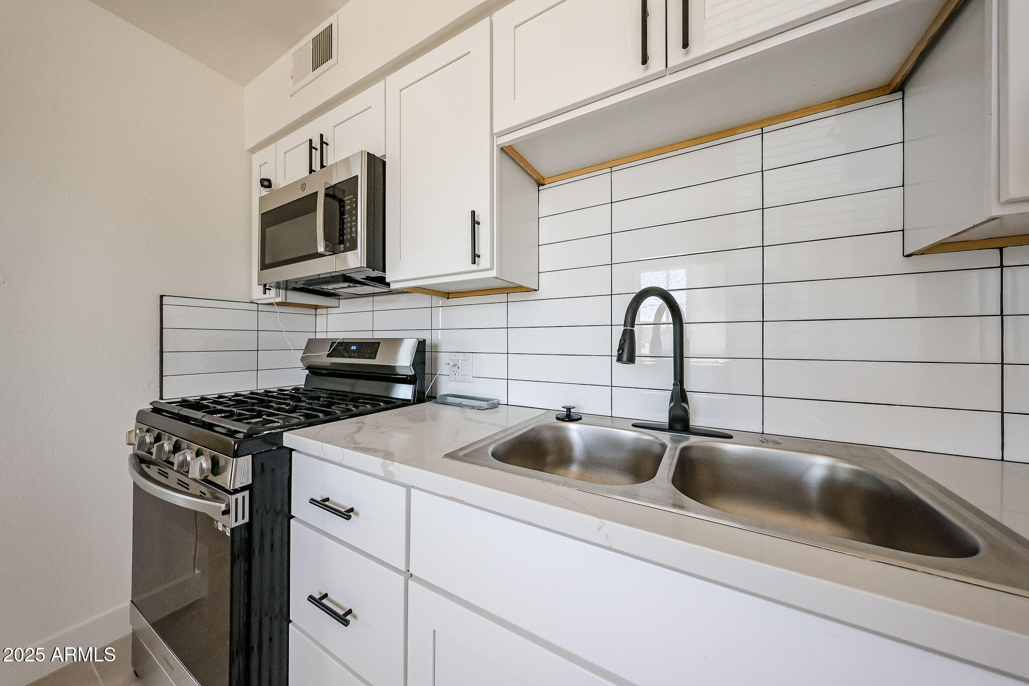 10202 North 15th Avenue, Unit 2 Phoenix, AZ 85021 - Photo 8 of 34 a kitchen with stainless steel appliances a sink a stove and cabinets